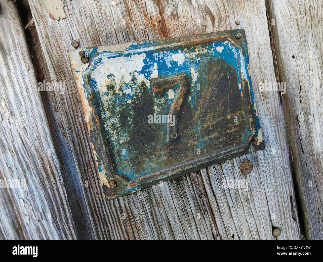 Rusty Seven: Segnatempo sulla porta di legno Foto Stock