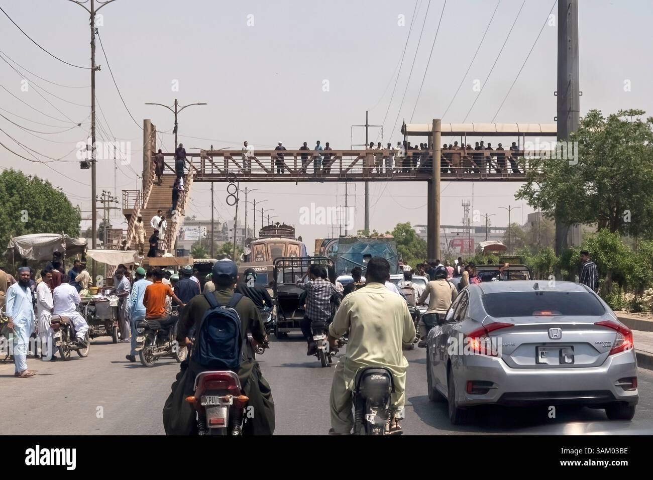 Gente che si riunisce nel luogo dopo un incidente stradale nell'area industriale di Karachi Pakistan Foto Stock