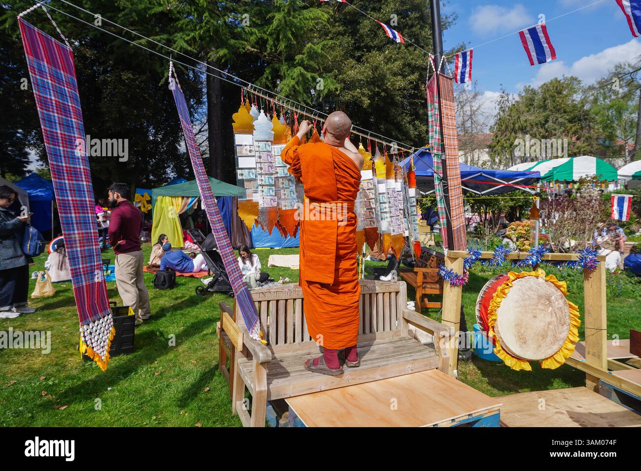 Londra Regno Unito 13 aprile 2025. Un monaco buddista offre denaro al festival del capodanno tailandese di Songkran al tempio Buddhapadipa a Wimbledon, a sud-ovest di Londra. Il festival simboleggia tradizionalmente il lavaggio dell'anno precedente che rappresenta la purificazione e un senso di rinnovamento e la gente visita i templi buddisti, dove portano offerte come cibo e denaro. Credit Amer Ghazzal/Alamy Live News Foto Stock