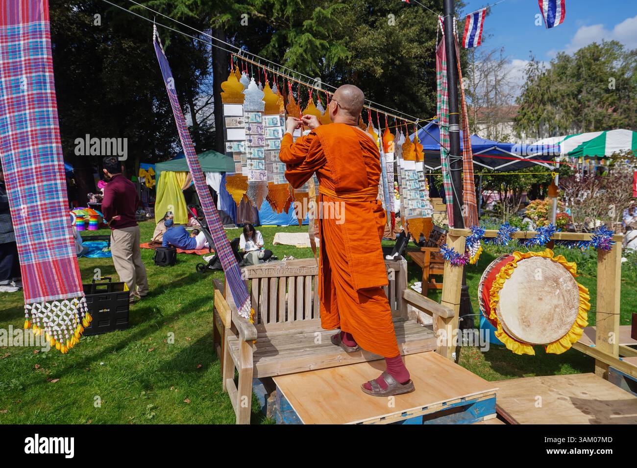 Londra Regno Unito 13 aprile 2025. Un monaco buddista offre denaro al festival del capodanno tailandese di Songkran al tempio Buddhapadipa a Wimbledon, a sud-ovest di Londra. Il festival simboleggia tradizionalmente il lavaggio dell'anno precedente che rappresenta la purificazione e un senso di rinnovamento e la gente visita i templi buddisti, dove portano offerte come cibo e denaro. Credit Amer Ghazzal/Alamy Live News Foto Stock
