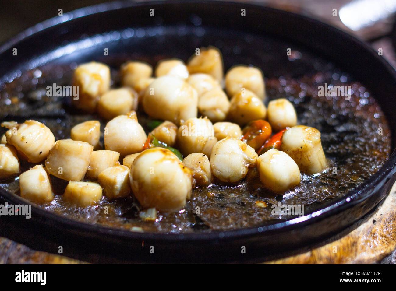 Carne di capesante sfrigolante servita su un piatto caldo in un ristorante locale a Iloilo, Filippine Foto Stock