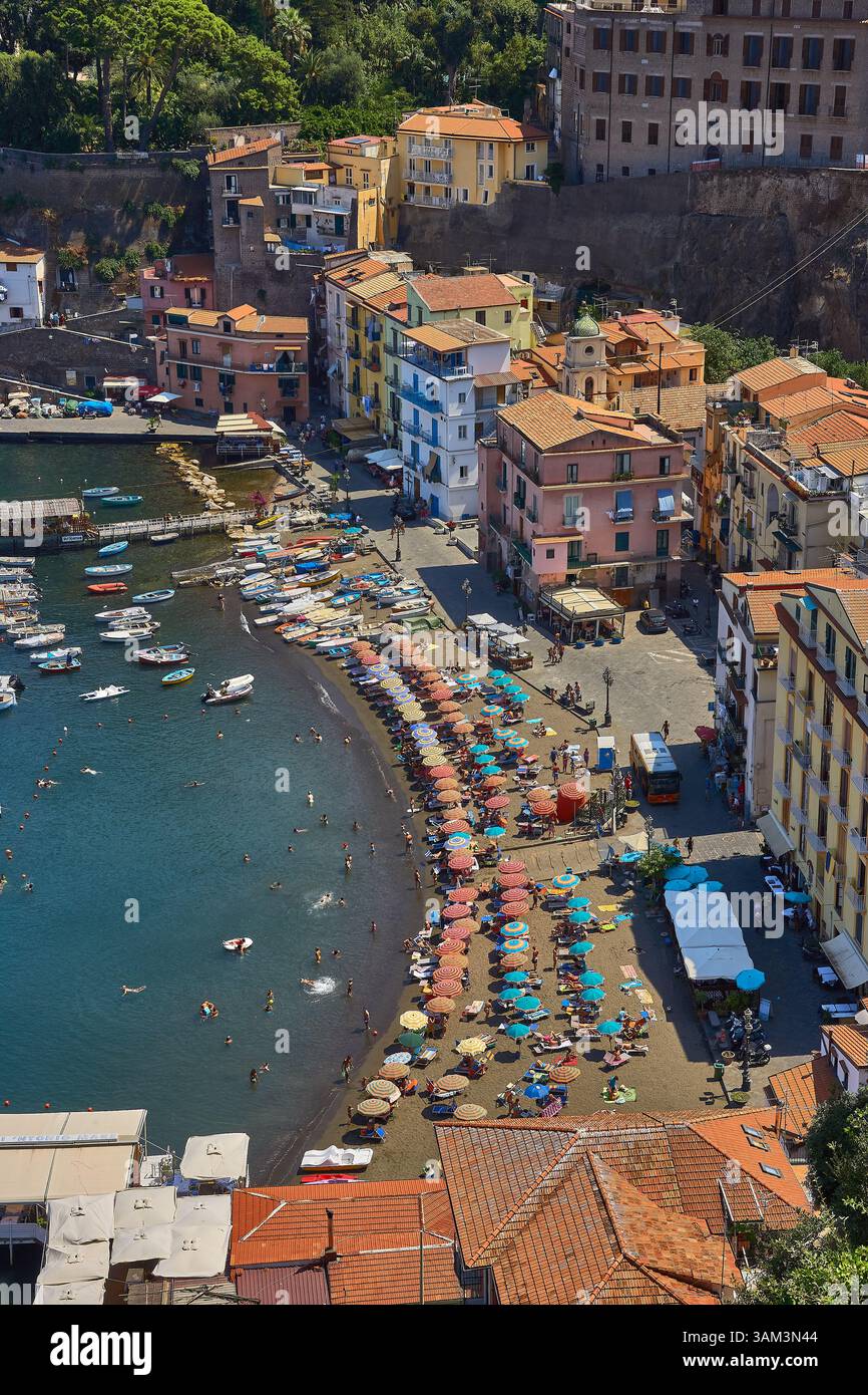 Pittoresca città costiera di Sorrento, in Italia, con spiaggia costeggiata da ombrelli e un'atmosfera vivace Foto Stock