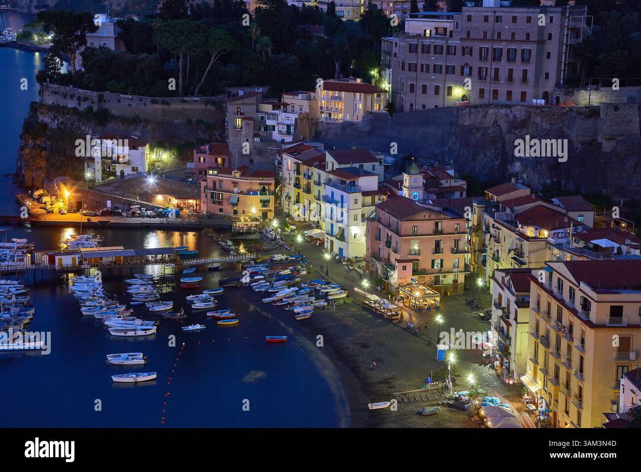 Vista panoramica di una città costiera del porto in Italia con edifici illuminati di notte Foto Stock