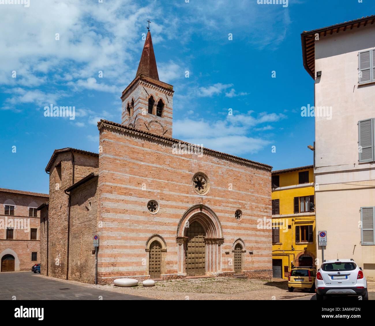 La Chiesa di San Salvatore a Foligno, Umbria, presenta una facciata in marmo rosso e bianco del XIV secolo con tre portali gotici. Foto Stock