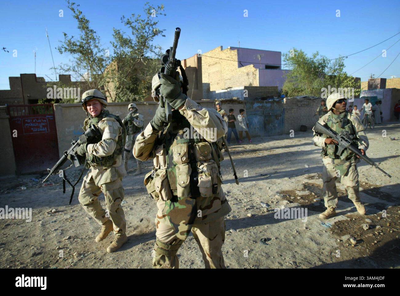 5 luglio 2004 - Stati Uniti - NIENTE MAGS, NESSUNA VENDITA -- KRT WORLD NEWS STORY SLUGGED: USIRAQ-WAREAGLE KRT FOTOGRAFIA DI BARBARA DAVIDSON/DALLAS MORNING NEWS (23 agosto) Sgt. Maggiore William J. Gainey, centro, del Multi National Corps of Iraq, controlla le attività sospette su un tetto a Kamalya, Baghdad, il 5 luglio 2004, durante una pattuglia piede di 6 miglia in territorio ostile della prima guerra Calvario. I soldati spesso distribuiscono caramelle e pacchetti umanitari agli iracheni che vivono in questa regione impoverita adiacente alla città di Sadr, a Baghdad, Iraq. (nk) 2004 Foto Stock