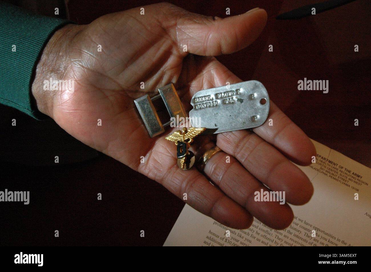10 febbraio 2005 - Stati Uniti - KRT LA NOTIZIA americana SLUGGED: ARMY-DENTIST KRT FOTOGRAFIA DI LAURENCE KESTERSON/PHILADELPHIA INQUIRER (15 febbraio) il Dr. Floyd E. Baker tiene le barre del capitano, le insegne mediche e il suo dog tag dal suo servizio dal 1946-48 come dentista nell'esercito a ft Bragg, Carolina del Nord. Il 84enne ha ricevuto una lettera da una stazione di reclutamento dell'esercito locale che lo invitava a riarruolarsi. (lde) 2005 (diversità) (immagine di credito: © Laurence Kesterson/mct/ZUMAPRESS.com) Foto Stock