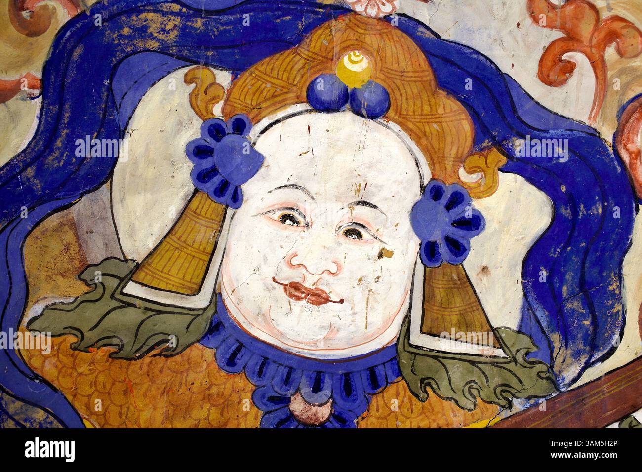 Dettaglio murale di un musicista celeste o di una figura assistente con elaborate decorazioni floreali e coiffure, monastero di Thiksey, Ladakh. Foto Stock