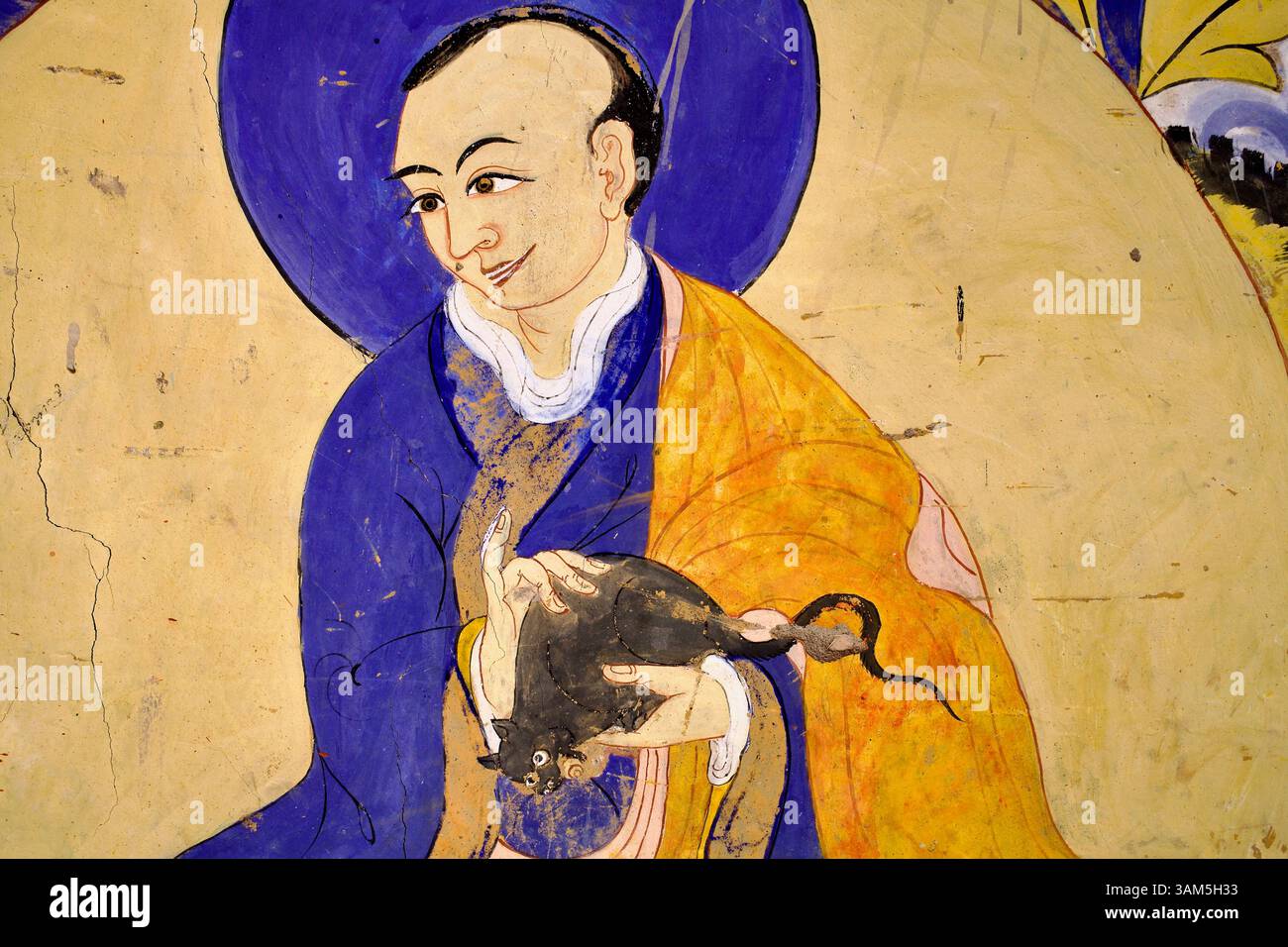 Murale di un monaco tibetano che regge dolcemente un topo, che illustra la compassione per tutti gli esseri senzienti, nel monastero di Thiksey, Ladakh. Foto Stock