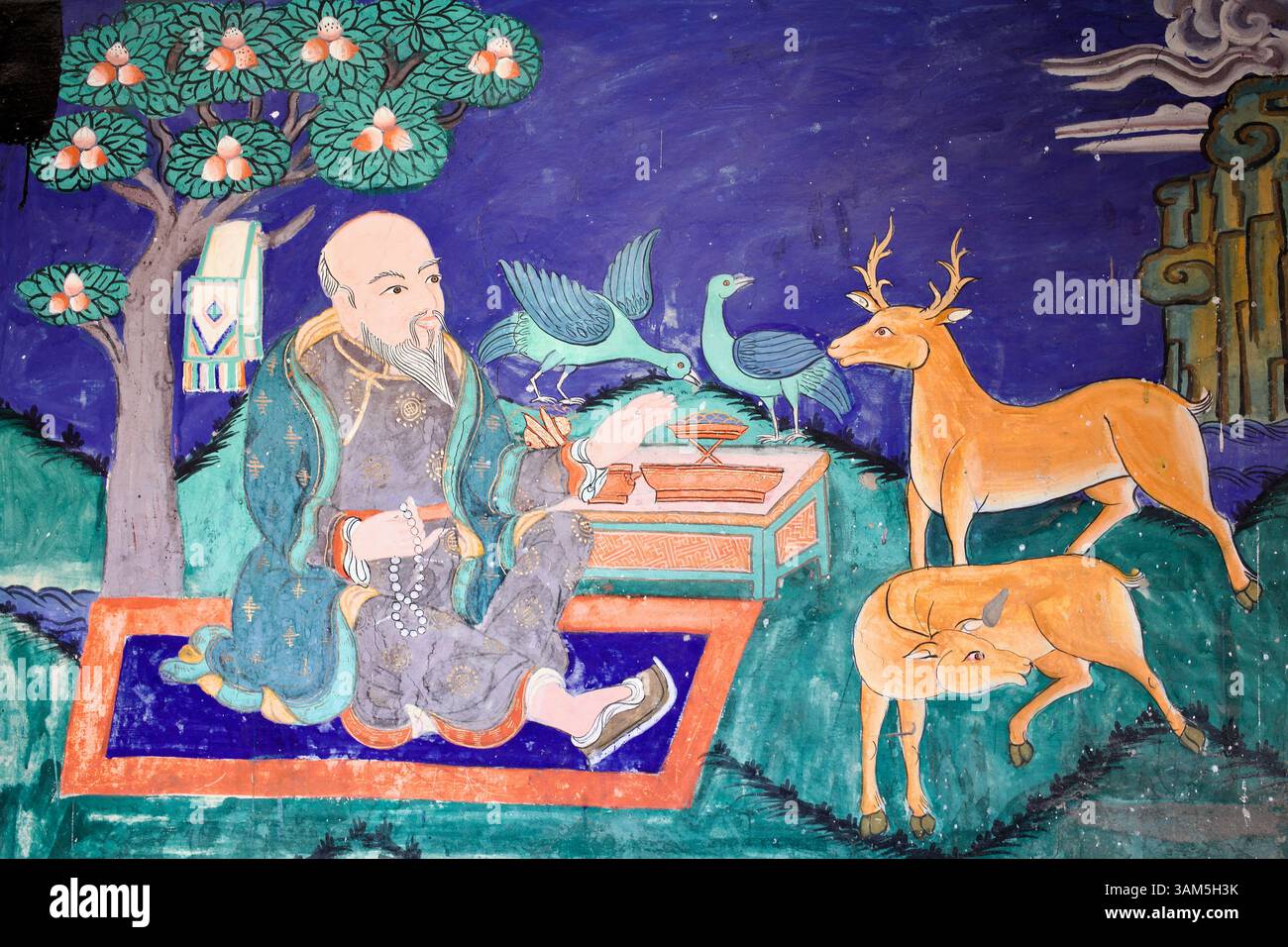 Murale che mostra un saggio in armonia con cervi e uccelli, simboleggiando l'universalità del Dharma, nel monastero di Thiksey, Ladakh. Foto Stock