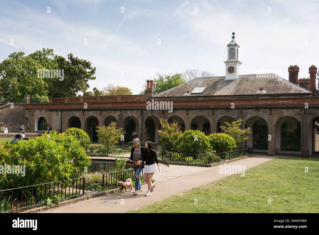 Una madre e una figlia che camminano con il loro cane nell'Iris Garden, Holland Park, West London, Inghilterra, Regno Unito. Foto Stock