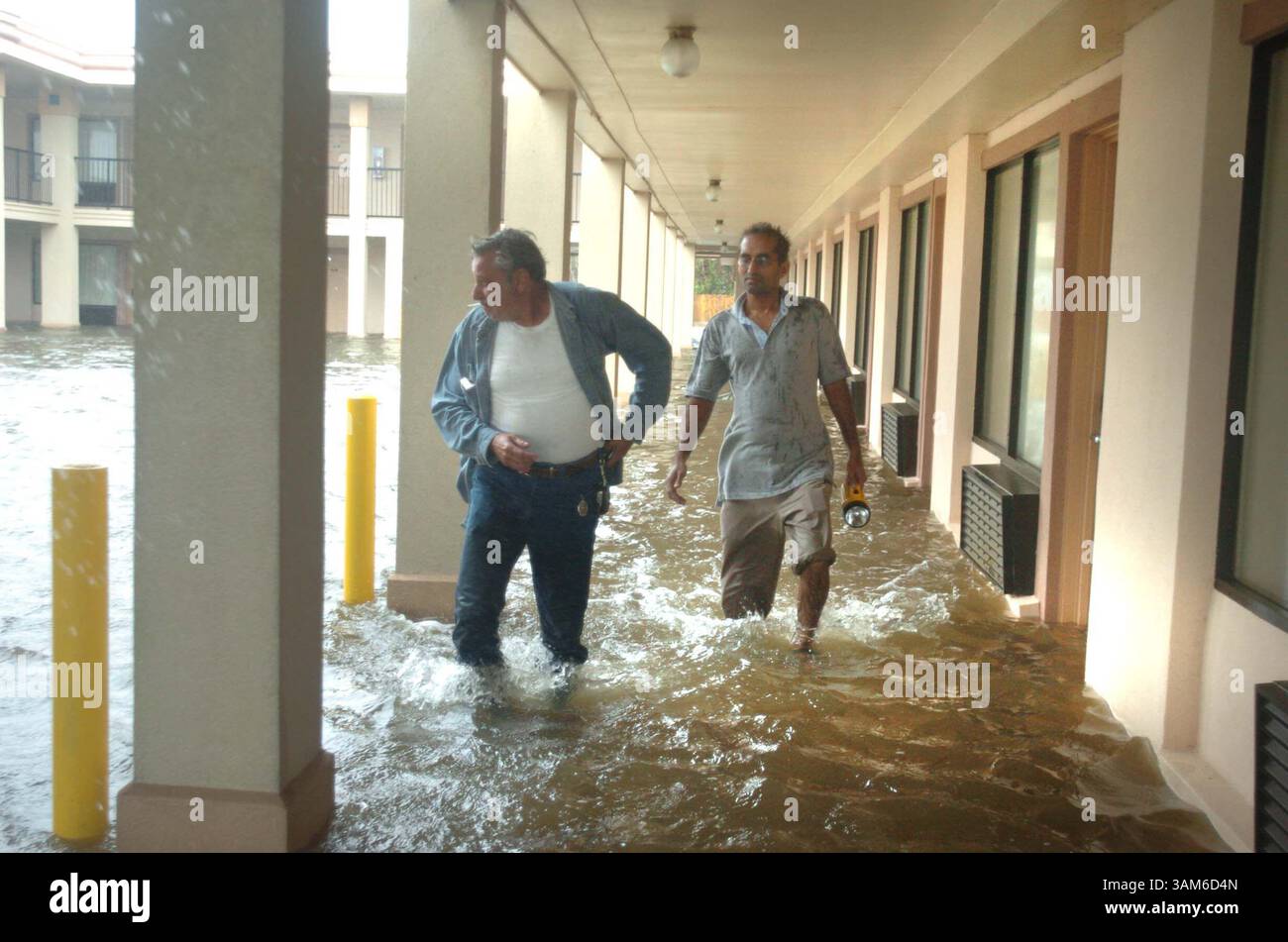 24 settembre 2005 - Stati Uniti - KRT US NEWS STORY SLUGGED: WEA-STORMS-LAKECHARLES KRT FOTOGRAFIA DI GEORGE SKENE/ORLANDO SENTINEL (MIAMI OUT) (24 settembre) LAKE CHARLES, LOUISIANA -- il proprietario del Days Inn Peter Patel, giusto, cammina attraverso l'acqua dal lago con un ospite nel suo motel a Lake Charles, Louisiana, sabato 24 settembre 2005. (Mvw) 2005 (immagine di credito: © George Skene/mct/ZUMAPRESS.com) Foto Stock
