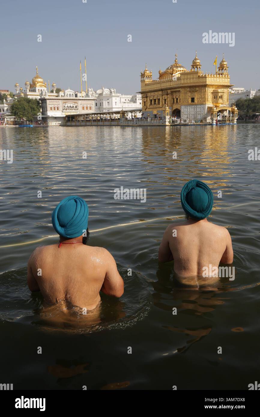 Festa Baisakhi celebrazioni al Tempio d'Oro, i devoti Sikh in India pregano mentre fanno un tuffo sacro nello stagno sacro chiamato Sarowar del Tempio d'Oro, il luogo più sacro dei Sikh in occasione del festival Visakhi o Baisakhi ad Amritsar, in India, il 13 aprile 2025. Nel 1699 d.C., Guru Gobind Singh Ji, il decimo Guru Sikh, istituì il Panth Khalsa, unendo i Sikh sotto un unico ordine. Questo evento importante viene commemorato durante il festival Visakhi, che segna anche l'inizio del capodanno Sikh. L'occasione è celebrata con grande devozione ed entusiasmo religioso, especial Foto Stock