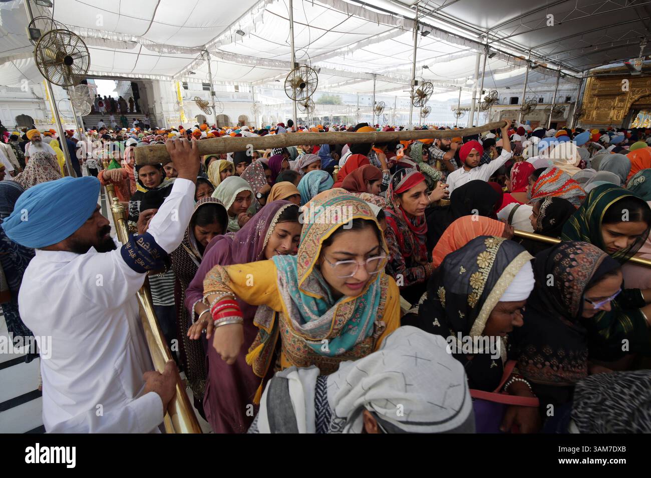 Le celebrazioni del festival Baisakhi al Tempio d'Oro, i devoti Sikh in India, in gran numero aspettano in coda per pagare l'obbedienza al Sanctum Sanctorum del Tempio d'Oro, il luogo più sacro dei Sikh in occasione del festival Visakhi o Baisakhi ad Amritsar, India, il 13 aprile 2025. Nel 1699 d.C., Guru Gobind Singh Ji, il decimo Guru Sikh, istituì il Panth Khalsa, unendo i Sikh sotto un unico ordine. Questo evento importante viene commemorato durante il festival Visakhi, che segna anche l'inizio del capodanno Sikh. L'occasione è celebrata con grande devozione religiosa ed enthusia Foto Stock