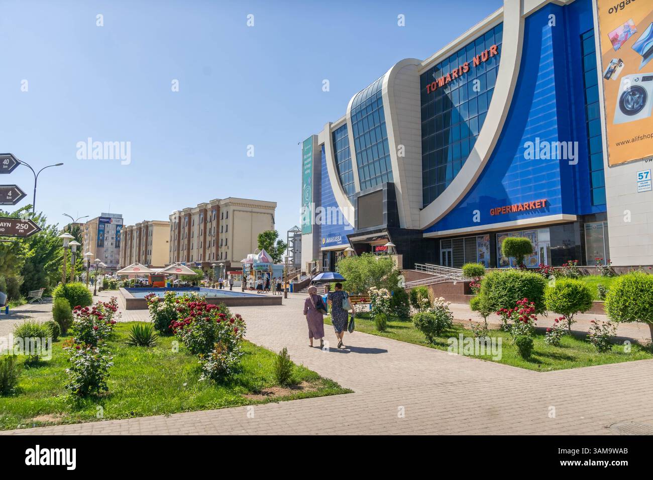 Il centro urbano di Urgench, un centro commerciale della città nella regione di Khorezm in Uzbekistan con architettura uzbeka e gente sulle strade della città. Foto Stock