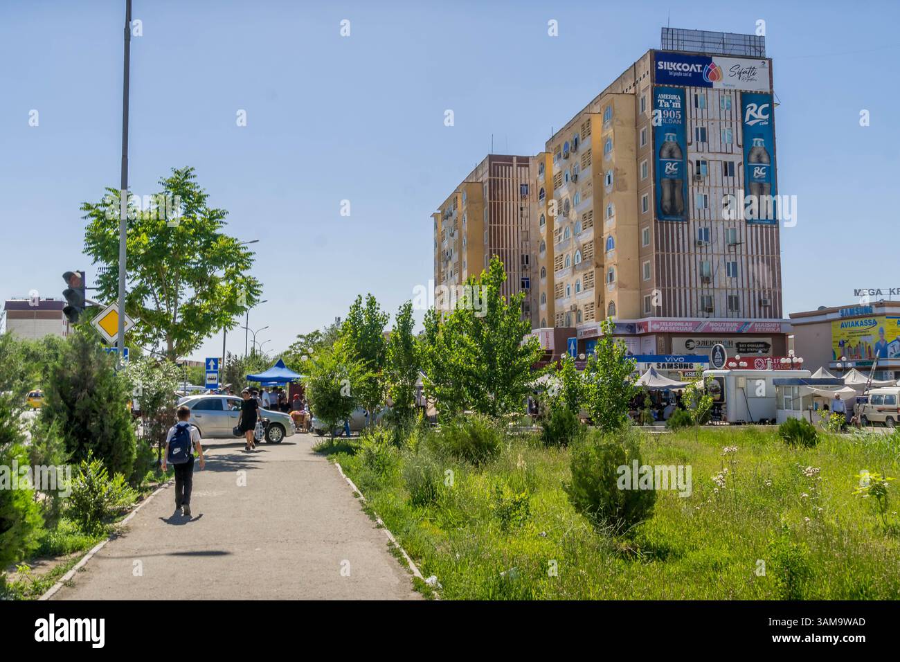 Il centro urbano di Urgench, un centro commerciale della città nella regione di Khorezm in Uzbekistan con architettura uzbeka e gente sulle strade della città. Foto Stock