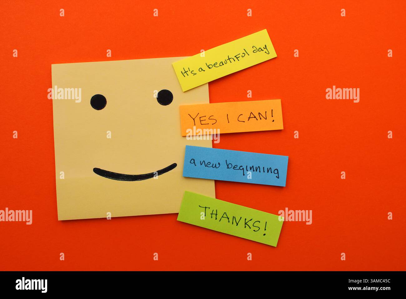 Faccia felice accanto a note colorate con frasi positive Foto Stock