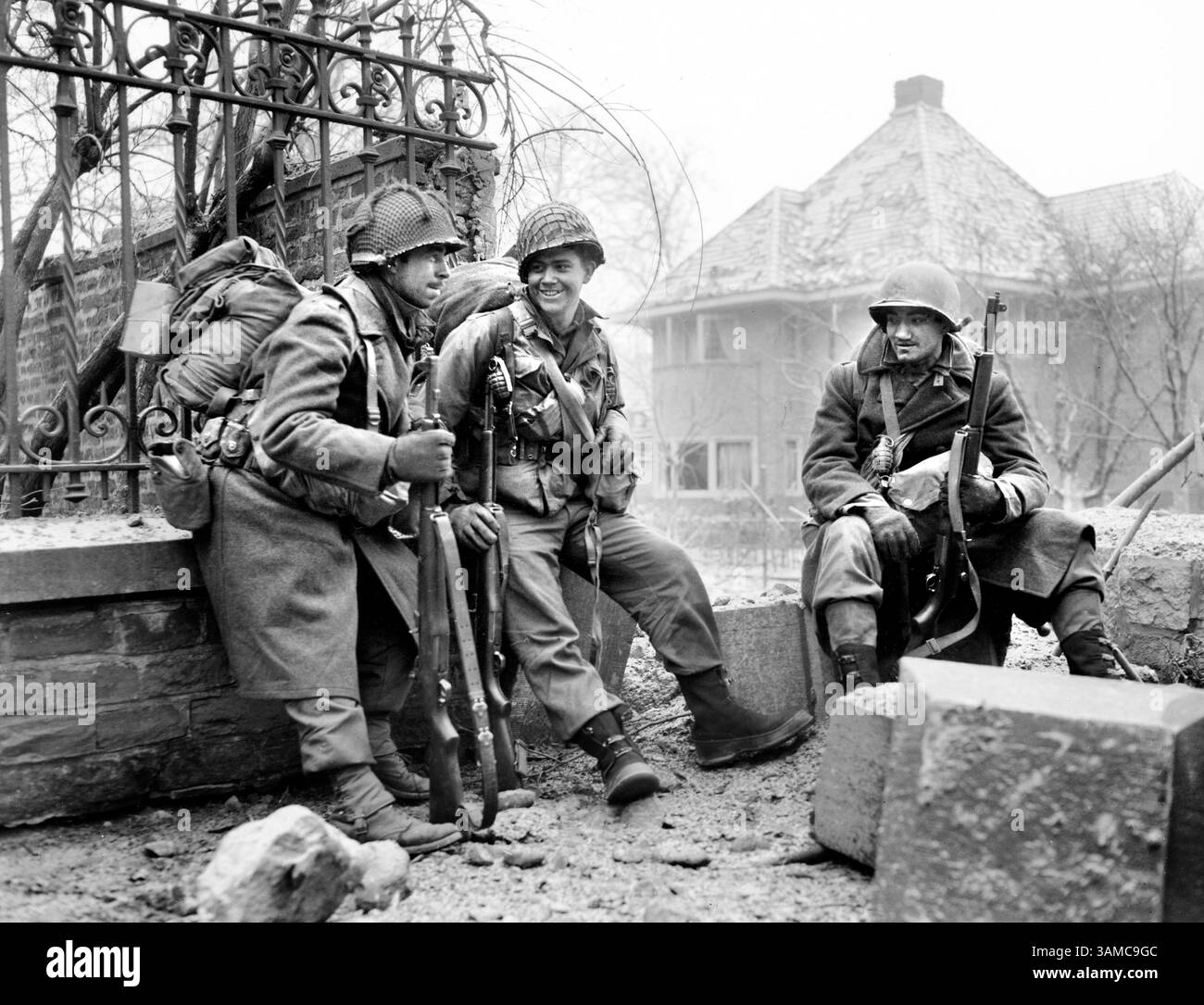 I fanti americani si fermano per riposarsi lungo il tragitto verso le linee del fronte, da sinistra a destra, sergente Lyle Greene, Rochester Minnesota, S/Sgt. Joseph DeMott, Greenwood, Ind., e PFC. Fred Mozzoni, Chicago, Illinois, vicino a Malmedy, Belgio, U.S. Army Signal Corps, 29 dicembre 1944 Foto Stock