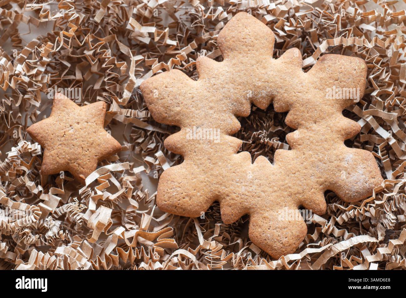 Torte di zenzero a forma di stella e fiocco di neve imbottite su ripieno di carta Foto Stock