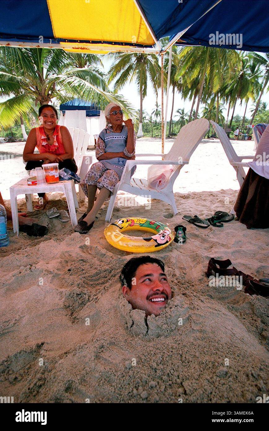 12 SETTEMBRE 2002 - STATI UNITI - KRT STORIA DI VIAGGIO IN SOSPENSIONE: ZIHUATANEJO KRT FOTO DI TOM UHLENBROCK/ST. LOUIS POST-DISPACCIO (14 ottobre) essere sepolto nella sabbia è un passatempo popolare a Playa la Ropa a Zihuatanejo, Messico. (SL) NC KD BL 2002 (Vert) (gsb) (immagine di credito: © St. Louis Post-Dispatch/mct/ZUMAPRESS.com) Foto Stock