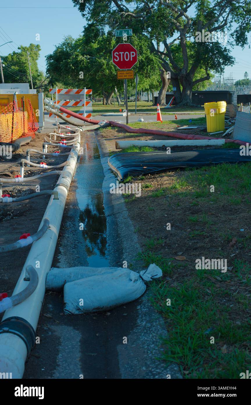 Strade in costruzione con barriere di sicurezza, tubi dell'acqua bianca temporanei e sistema di drenaggio. Tubi di drenaggio, coni di avvertenza e attrezzature che garantiscono Foto Stock