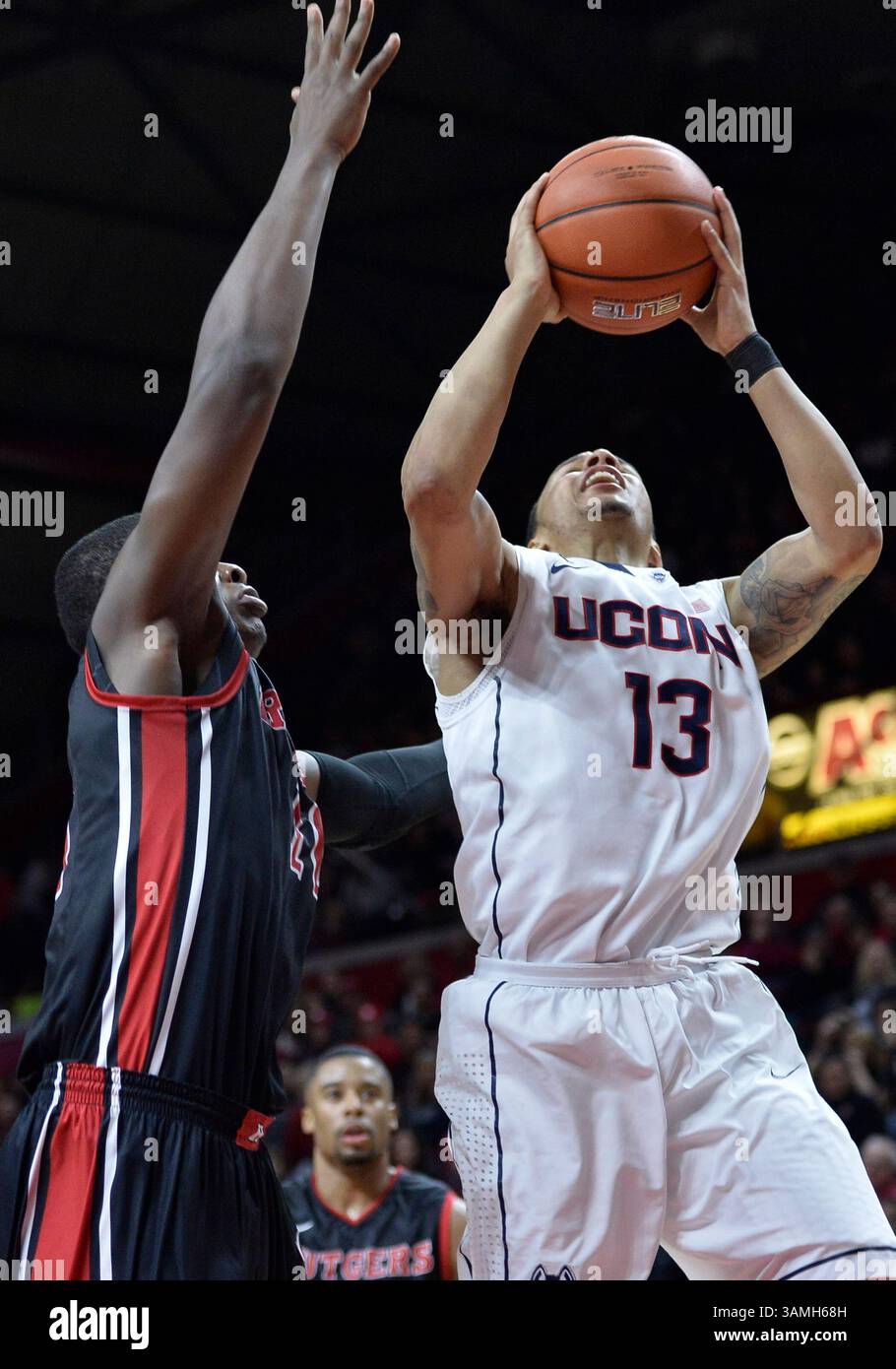 25 gennaio 2014 - Piscataway, NJ, USA - sabato 25 gennaio 2014: La guardia Shabazz Napier (13) del Connecticut Huskies va in cestino contro i Rutgers Scarlet Knights, guardia-attaccante Junior Etou (10) difendendo durante la seconda metà della partita di basket NCAA tra Rutgers e Connecticut al Louis Brown Athletic Center di Piscataway, New Jersey UConn ha battuto Rutgers 82-71. Bill Shettle / Cal Sport Media. (Immagine di credito: © Bill Shettle/Cal Sport Media/ZUMAPRESS.com) Foto Stock