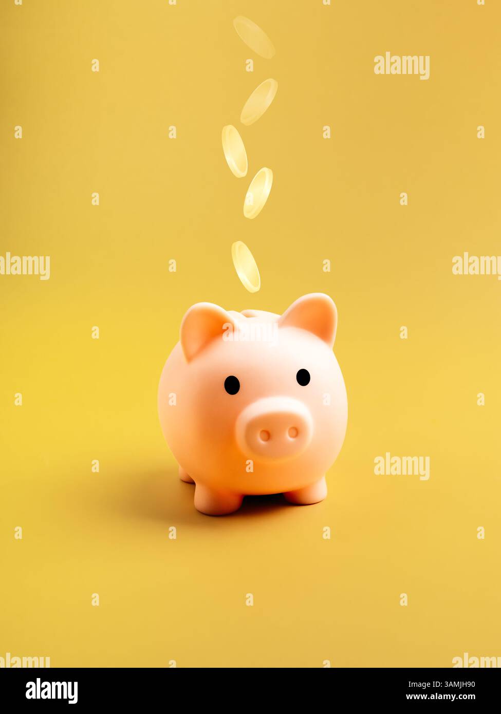 Risparmio di denaro, piano pensionistico, budget per la sicurezza, concetto di investimento aziendale. Grazioso salvadanaio rosa con monete d'oro cadenti isolate su giallo co Foto Stock