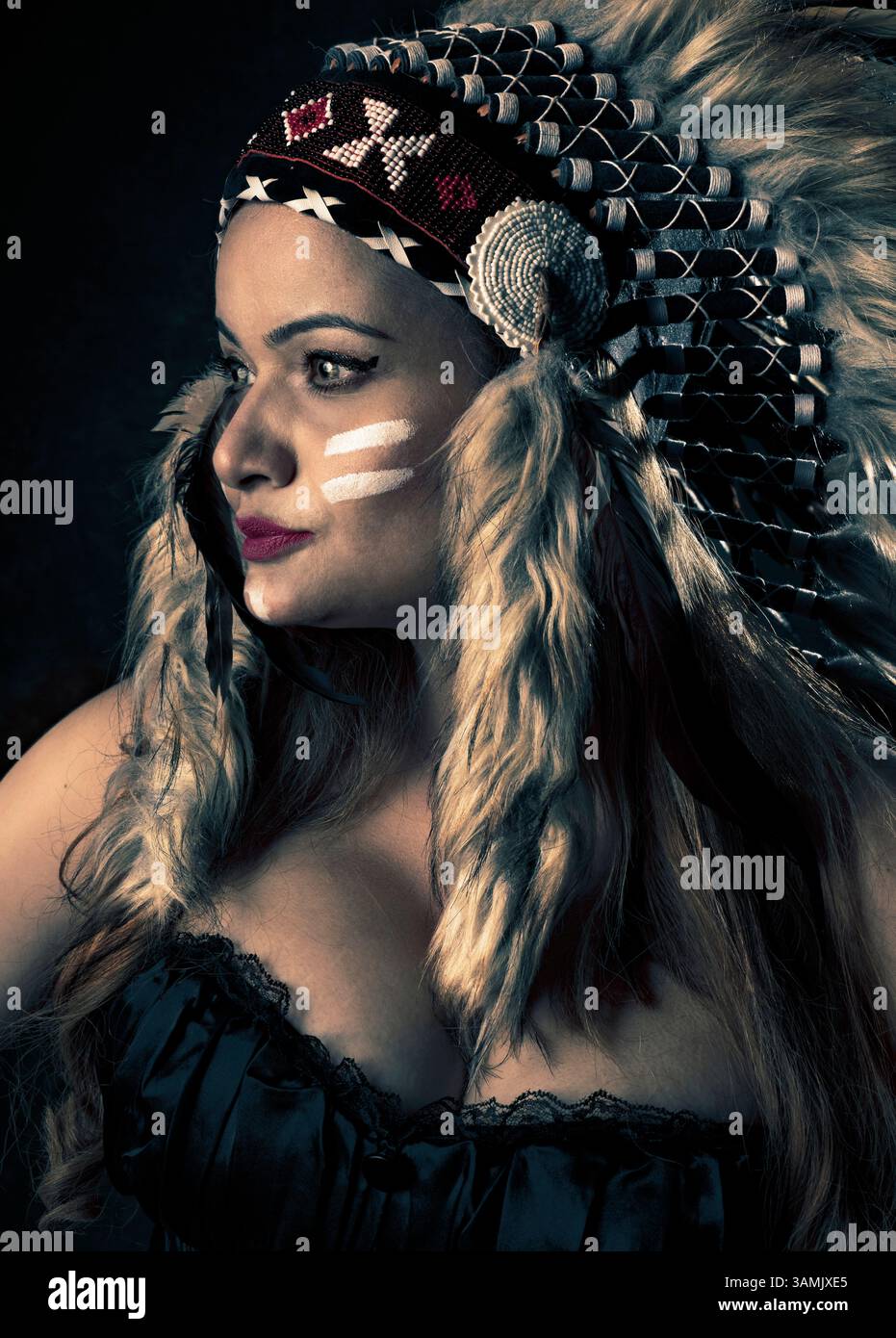 Una donna con un abbigliamento stilizzato ispirato ai nativi americani posa per un ritratto concettuale e una fotografia artistica. Non rappresentativo di nessuna tribù specifica Foto Stock