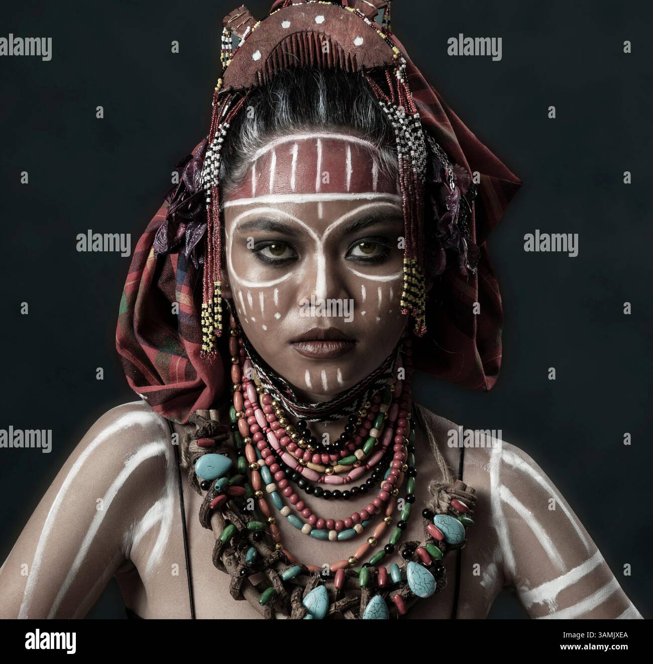 Ritratto di una donna in abito tribale con pittura del viso, collane colorate con perline e capo. L'immagine rappresenta l'espressione culturale Foto Stock