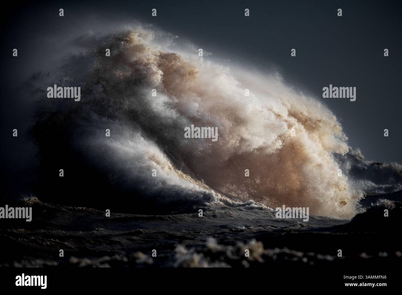 Immagine a colori del paesaggio costiero che mostra le onde, frustate da forti venti fino al punto in cui sembrano esplodere dall'acqua. Foto Stock