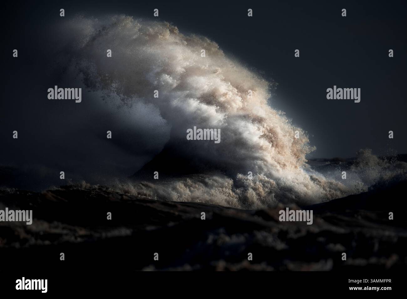 Immagine a colori del paesaggio costiero che mostra le onde, frustate da forti venti fino al punto in cui sembrano esplodere dall'acqua. Foto Stock