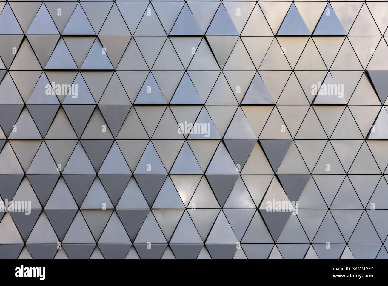 Facciata di futuristiche pareti architettoniche ricoperte da motivi triangolari in varie sfumature di grigio, design urbano astratto Foto Stock