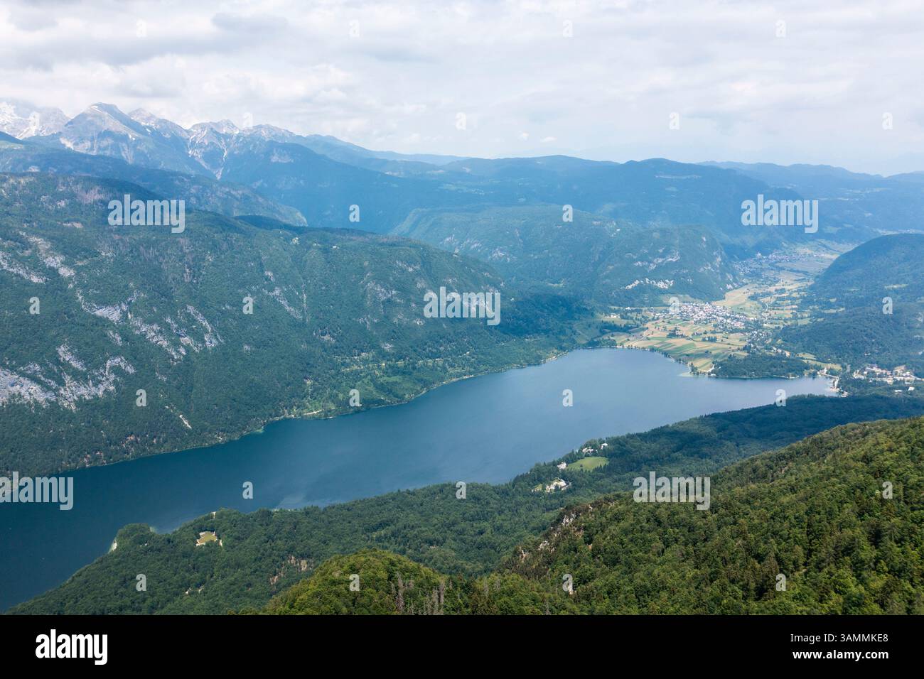 Vista aerea di un lago tranquillo e pittoresco circondato da montagne maestose e vegetazione lussureggiante, Ribcev Laz, Slovenia. Foto Stock
