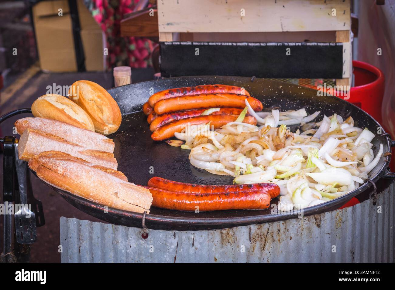 Salsiccia con cipolle servita con baguette Street food al Brick Lane Market di Londra Foto Stock