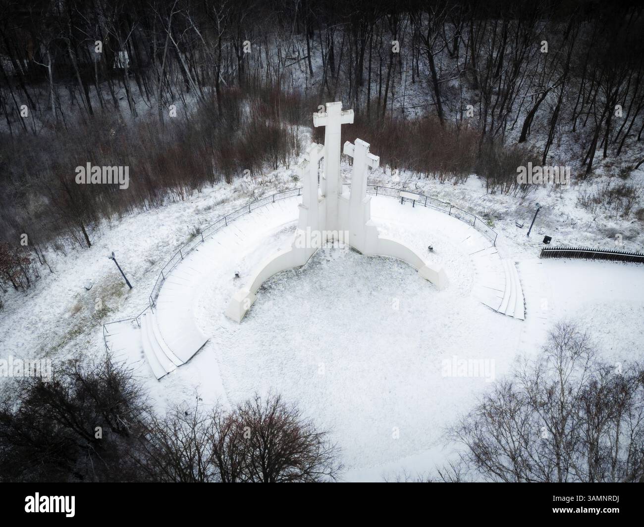 Vista aerea del monumento a tre croci circondato da una foresta innevata e da un tranquillo paesaggio, Vilnius, Lituania. Foto Stock