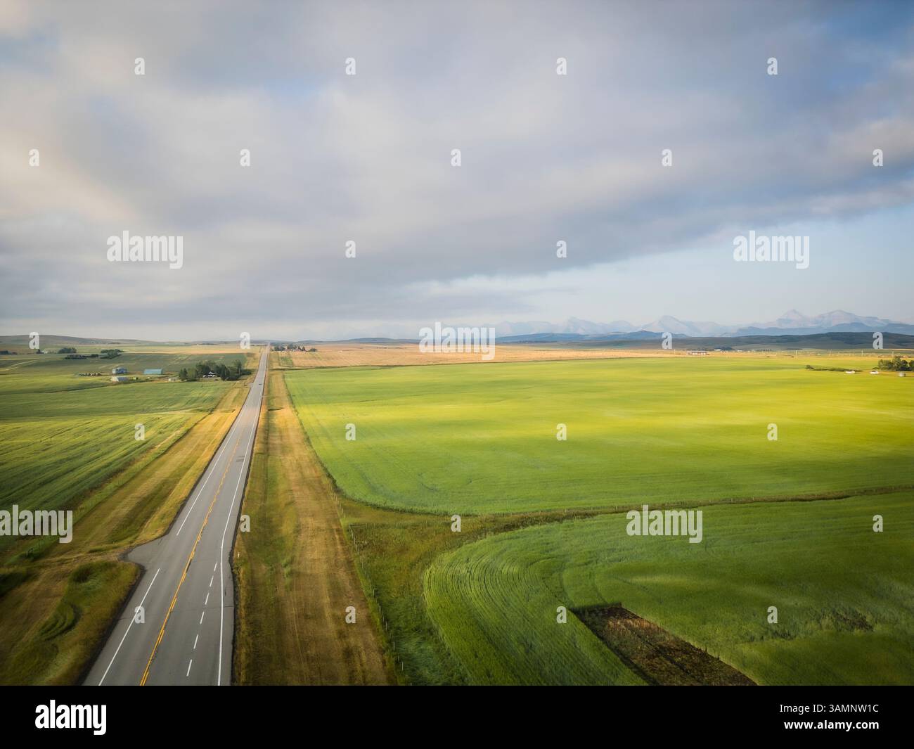 Vista aerea di splendidi campi e montagne con una strada di campagna, Pincher Creek, Canada. Foto Stock