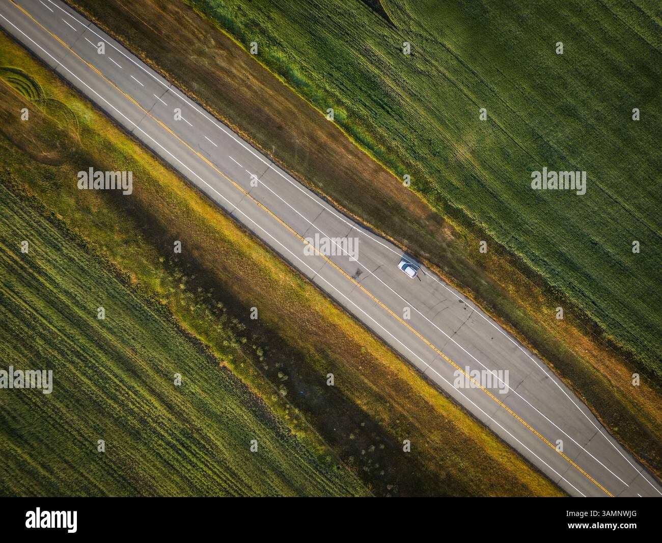 Vista aerea di splendidi campi e una strada con una sola auto, Pincher Creek, Canada. Foto Stock