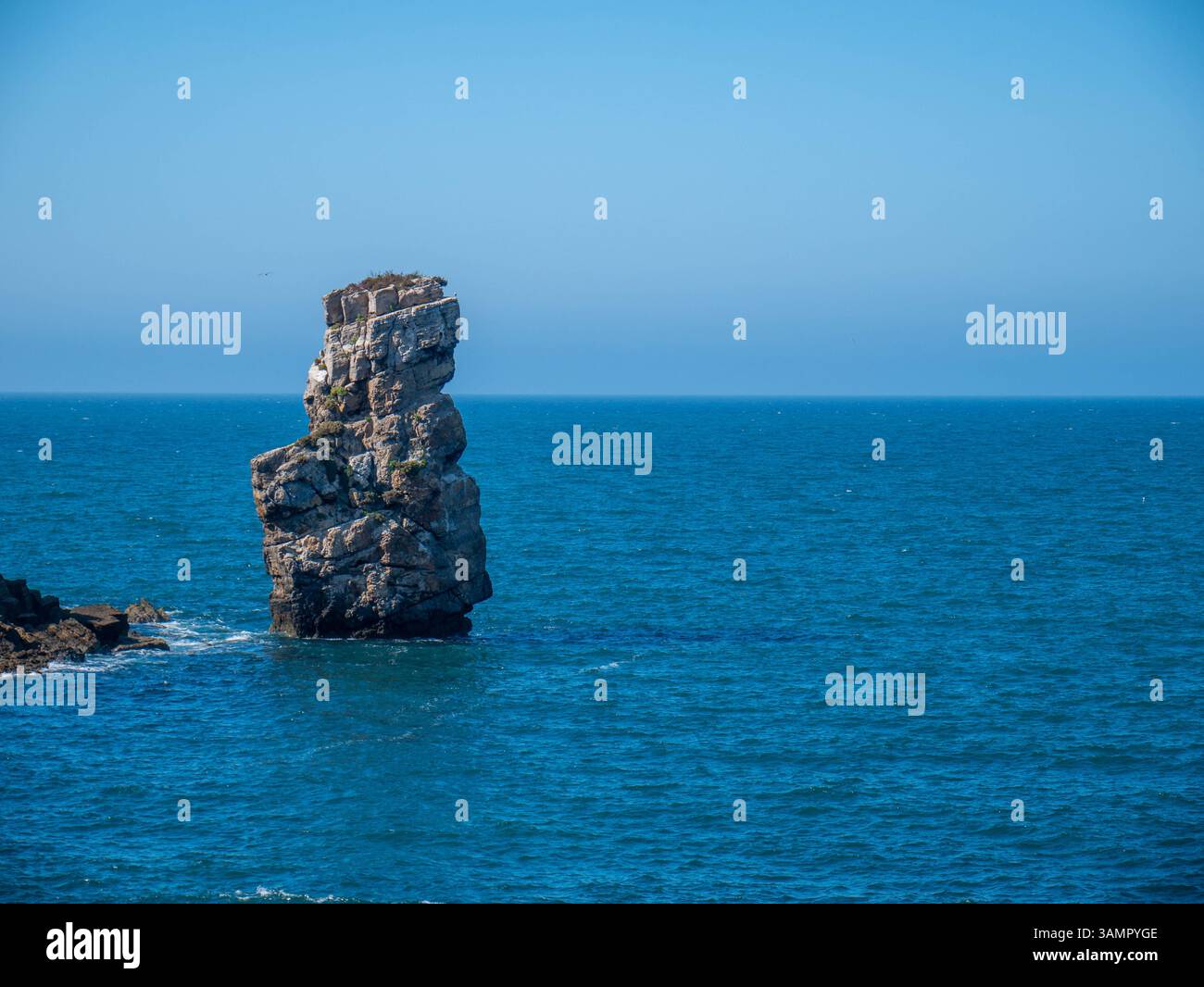 Isola isolata delle Montagne Rocciose circondata dalle profonde acque blu dell'Oceano il giorno della soleggiata in Portogallo Foto Stock