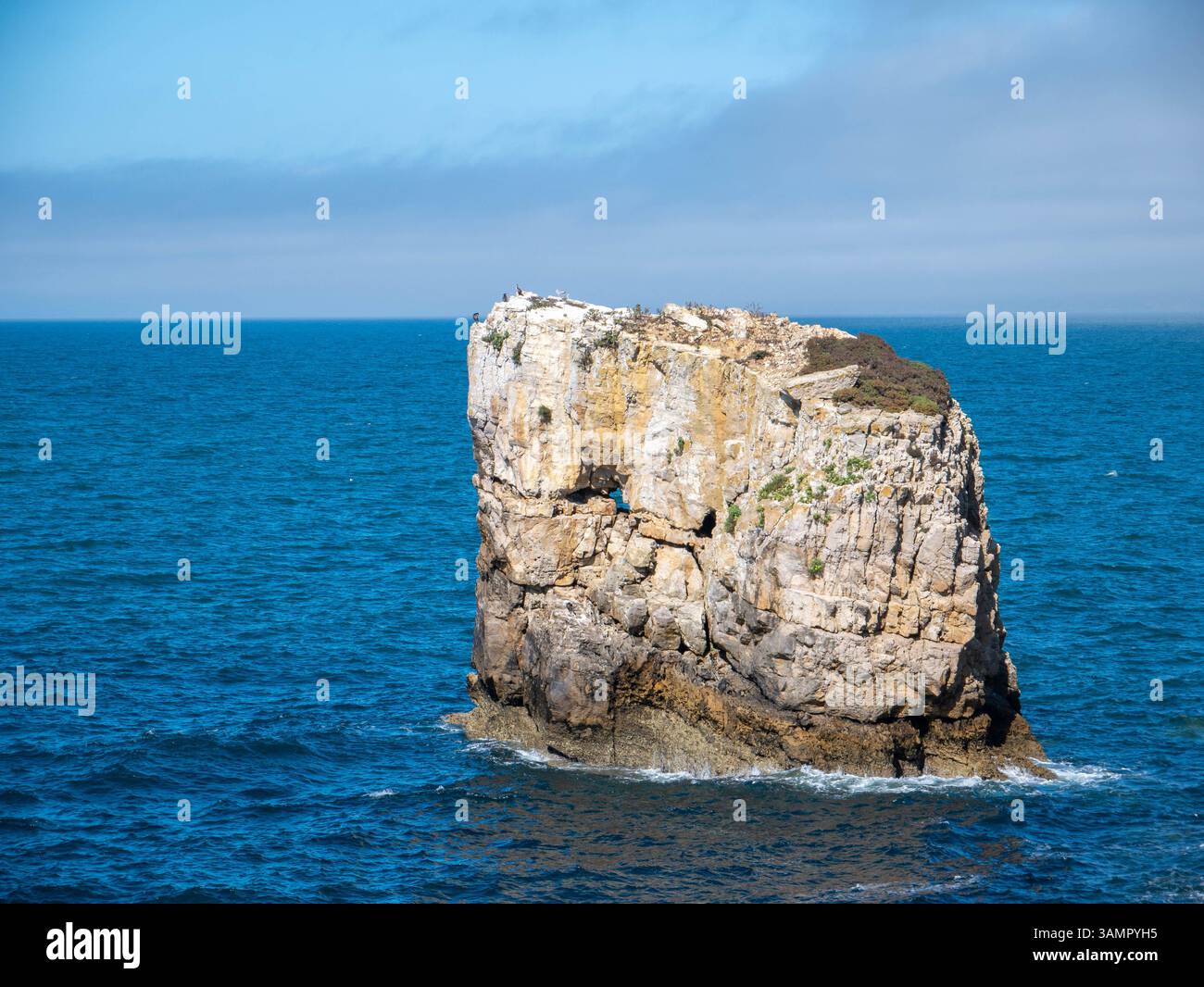 Isola isolata delle Montagne Rocciose circondata dalle profonde acque blu dell'Oceano il giorno della soleggiata in Portogallo Foto Stock