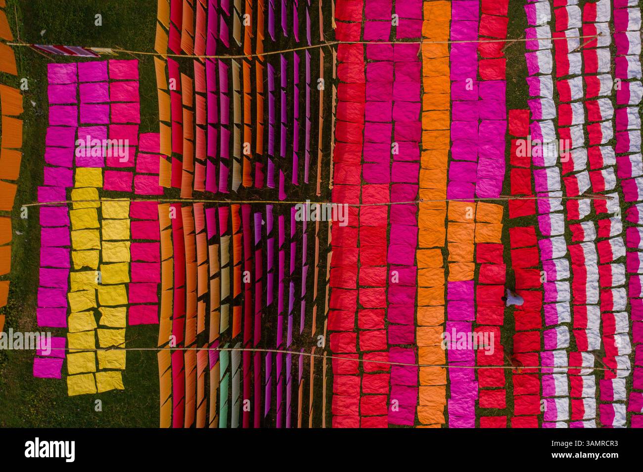 Vista aerea di centinaia di fogli di tessuto multicolore che si asciugano sotto la luce del sole a Narayanganj, Bangladesh. Foto Stock