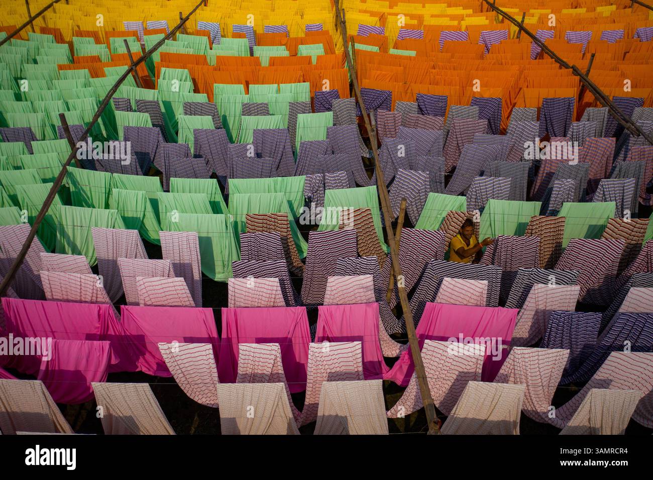 Vista aerea di centinaia di fogli di tessuto multicolore che si asciugano sotto la luce del sole a Narayanganj, Bangladesh. Foto Stock