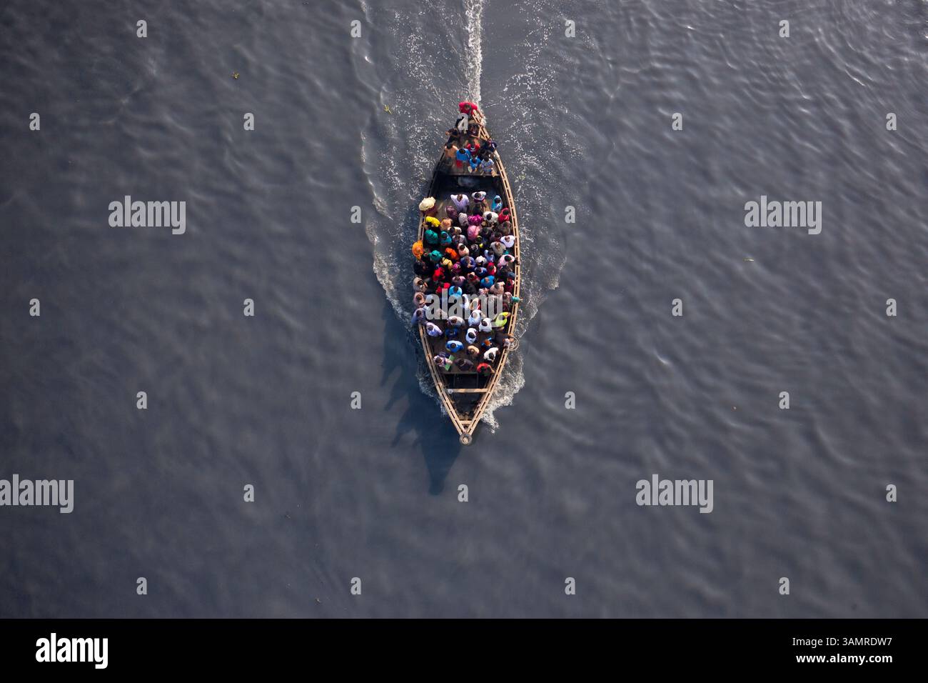 Vista aerea di un traghetto in legno pieno di passeggeri che navigano attraverso il fiume Shitalakshya a Bandar, divisione di Dhaka, Bangladesh. Foto Stock