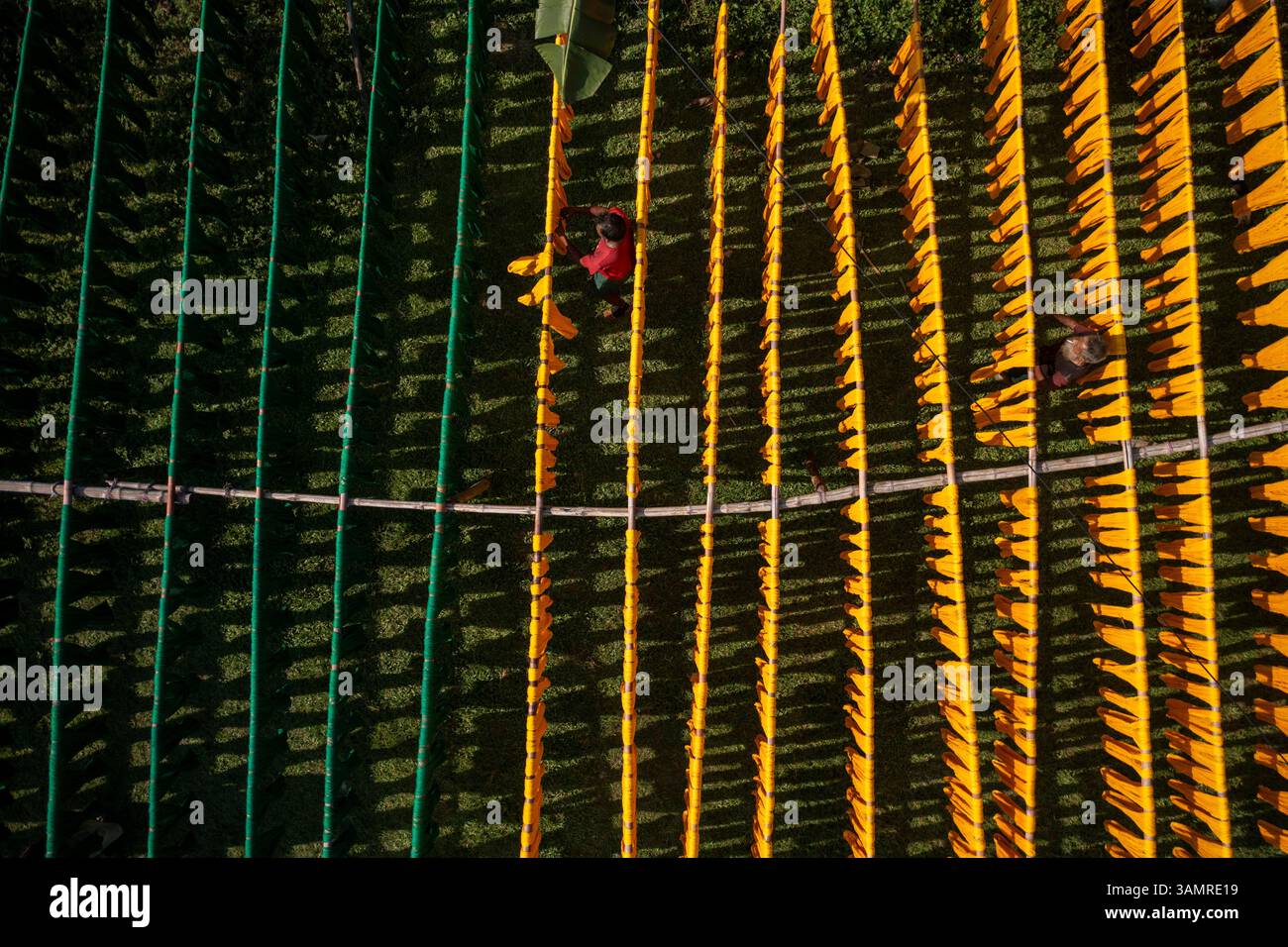 Vista aerea di vivaci file di tessuti colorati che si asciugano in un laboratorio tessile, Satgram, Araihazar, Dacca, Bangladesh. Foto Stock