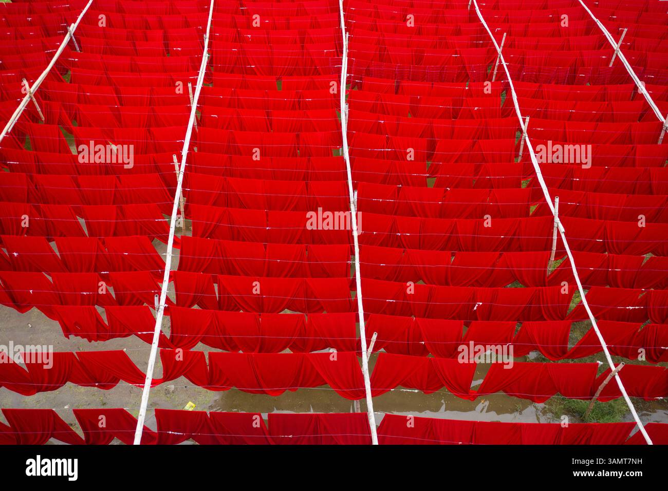 Vista aerea dei lavoratori che appendono tessuti colorati per t-shirt da asciugare a Narayanganj, Dacca, Bangladesh. Foto Stock
