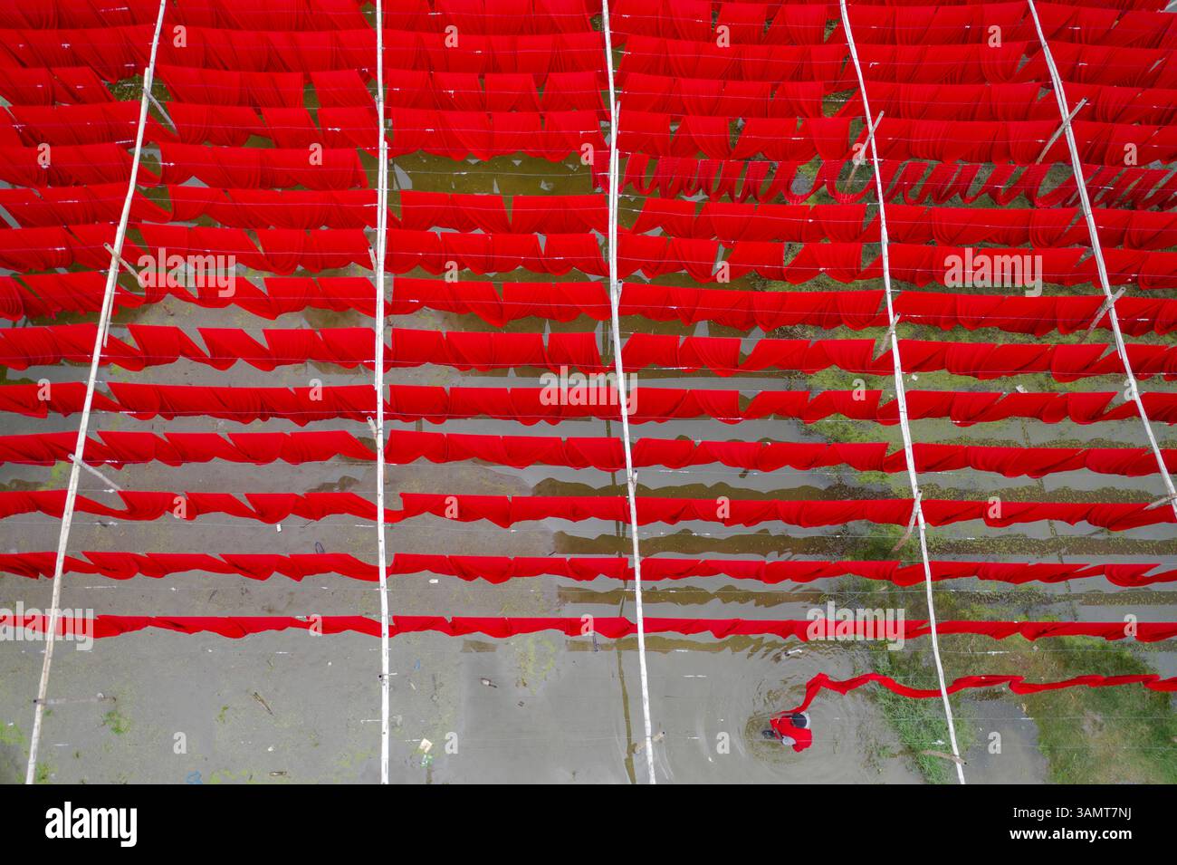 Vista aerea dei lavoratori che appendono tessuti colorati per t-shirt da asciugare a Narayanganj, Dacca, Bangladesh. Foto Stock