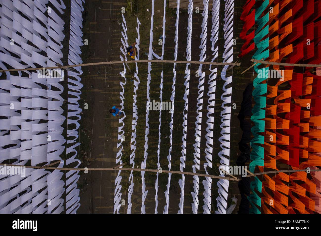 Dhaka, Bangladesh - 18 maggio 2021: Veduta aerea di lavoratori appesi a migliaia di metri di diversi tessuti di t-shirt colorati da asciugare a Narayanganj, Dhaka Foto Stock