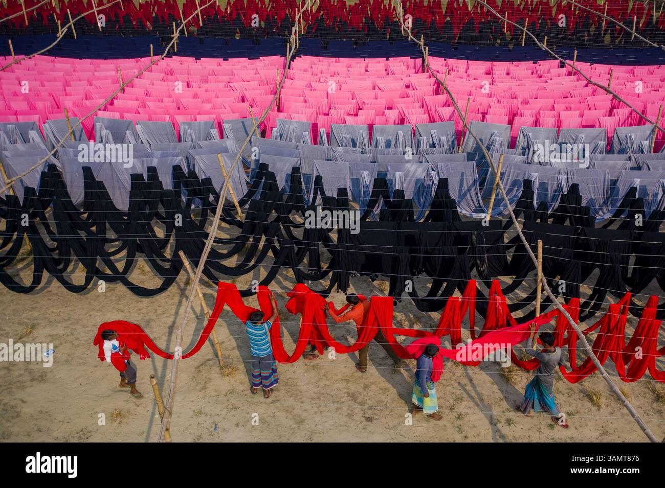 Dhaka, Bangladesh - 18 maggio 2021: Veduta aerea di lavoratori appesi a migliaia di metri di diversi tessuti di t-shirt colorati da asciugare a Narayanganj, Dhaka Foto Stock