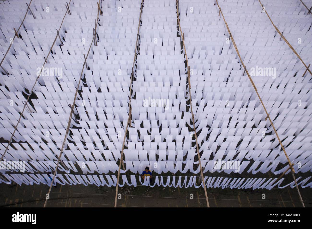 Dhaka, Bangladesh - 18 maggio 2021: Veduta aerea di lavoratori appesi a migliaia di metri di diversi tessuti di t-shirt colorati da asciugare a Narayanganj, Dhaka Foto Stock
