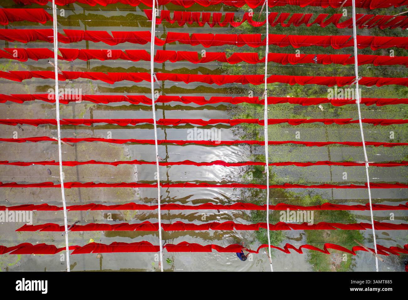 Vista aerea dei lavoratori che appendono tessuti colorati per t-shirt da asciugare a Narayanganj, Dacca, Bangladesh. Foto Stock