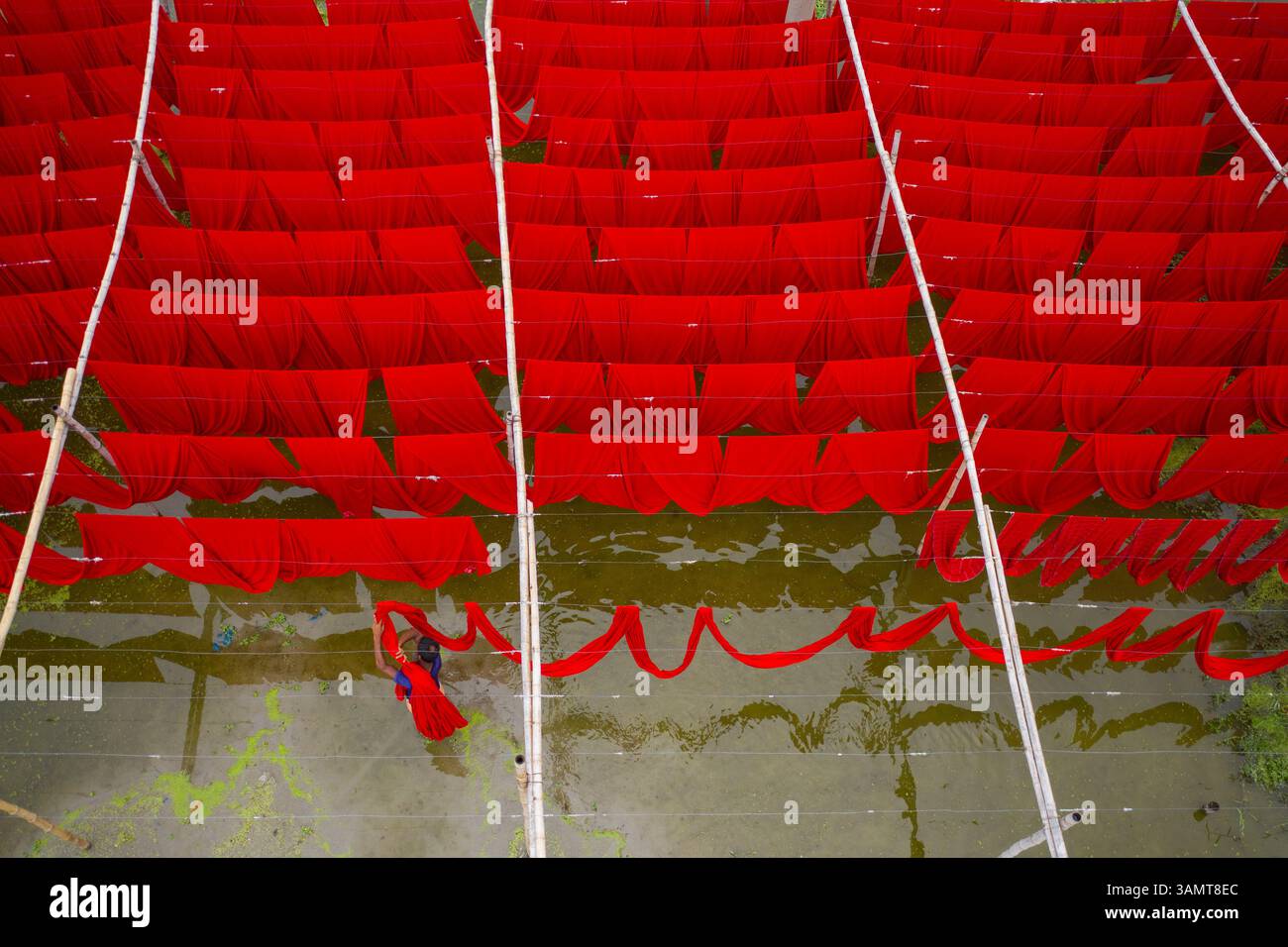 Vista aerea dei lavoratori che appendono tessuti colorati per t-shirt da asciugare a Narayanganj, Dacca, Bangladesh. Foto Stock
