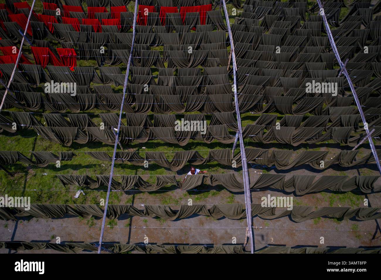 Dhaka, Bangladesh - 18 maggio 2021: Veduta aerea di lavoratori appesi a migliaia di metri di diversi tessuti di t-shirt colorati da asciugare a Narayanganj, Dhaka Foto Stock